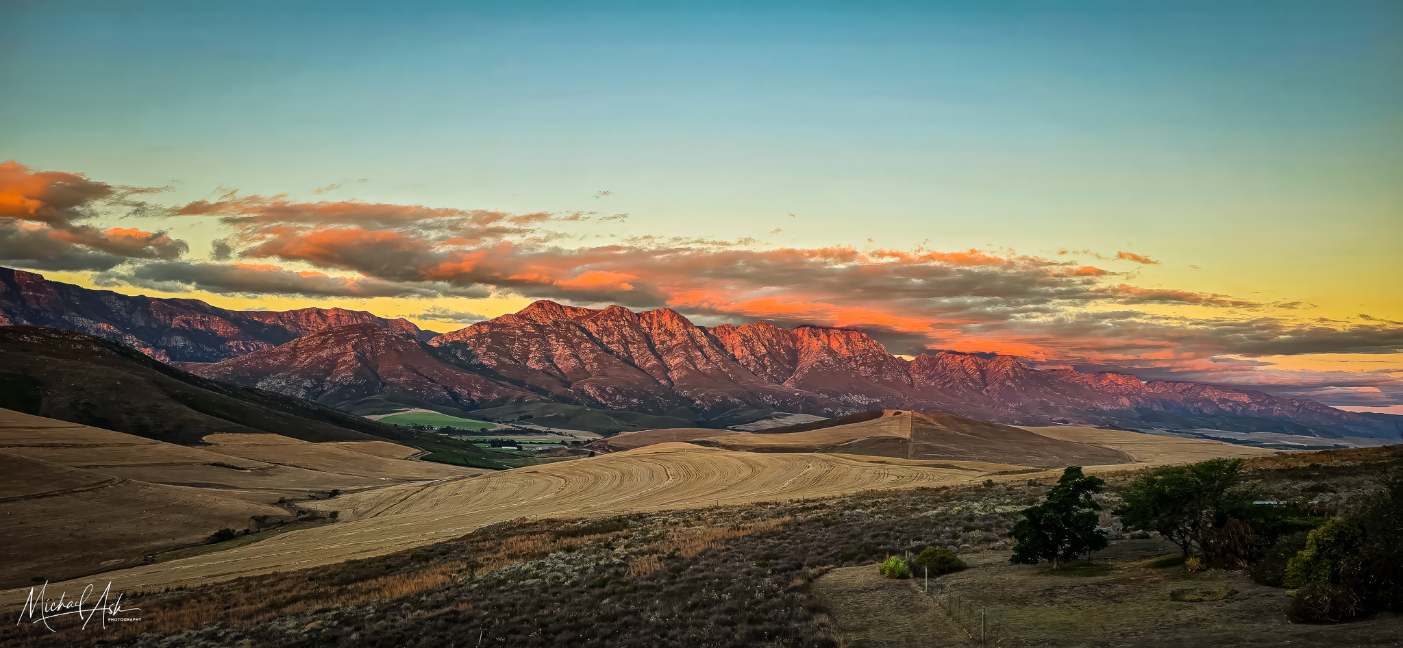 Landscape & Views Dramatic sunset showing red alpenglow on mountain ranges, rolling farmland fields, and spectacular sky