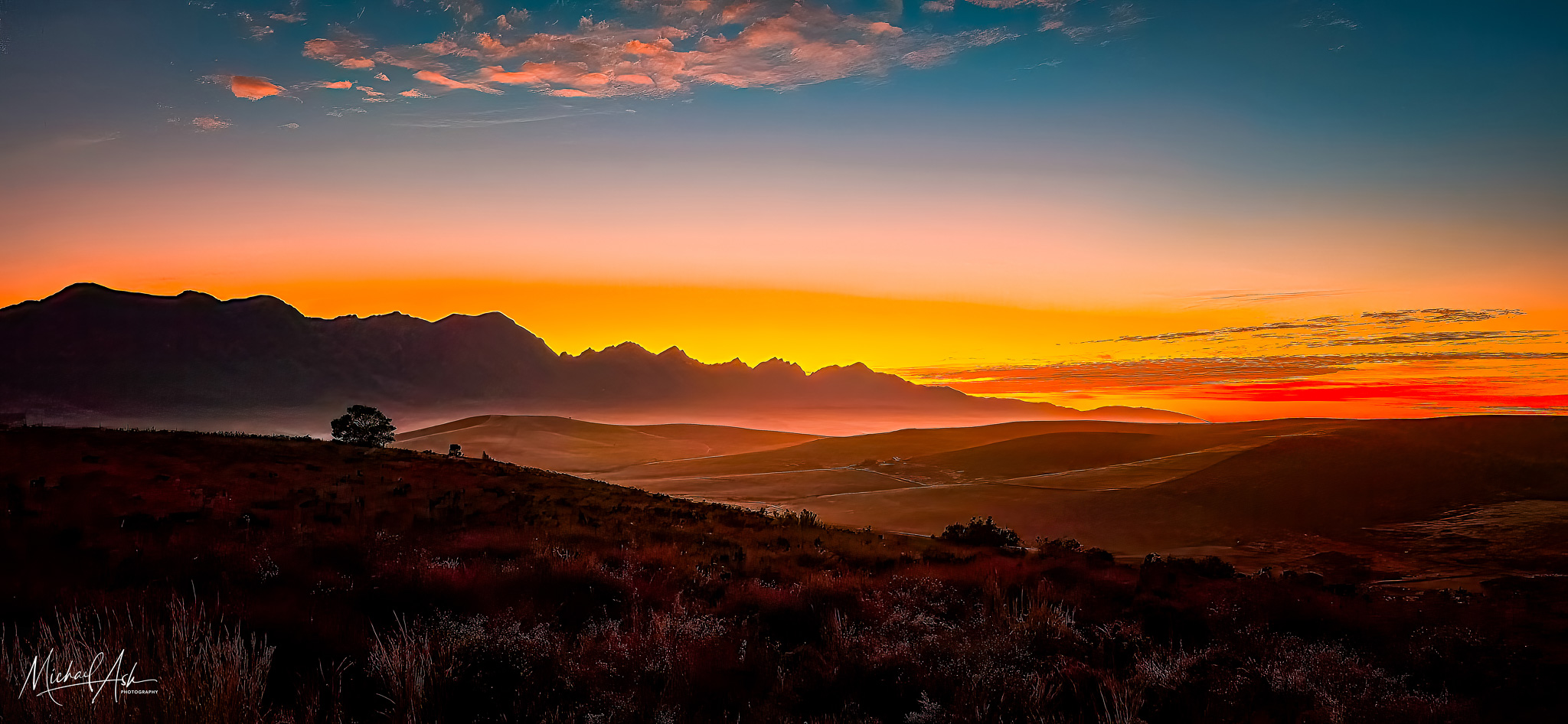 Landscape & Views Sunrise landscape showing dramatic mountain silhouettes against vibrant orange and red sky