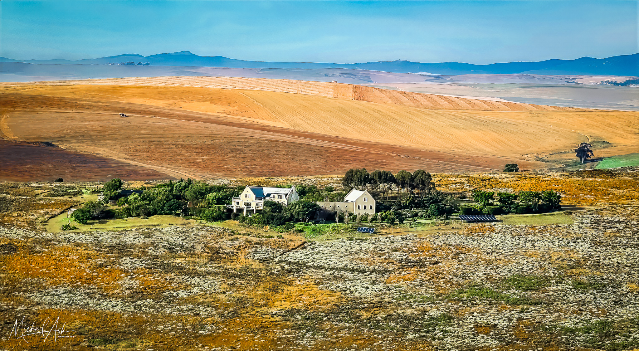 Exterior & Architecture Aerial view of Clapper Lark Farm showing entire property complex with main house, guest cottage, solar panels, and landscaping set against golden Overberg countryside